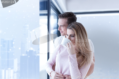 Image of young couple enjoying morning coffee by the window