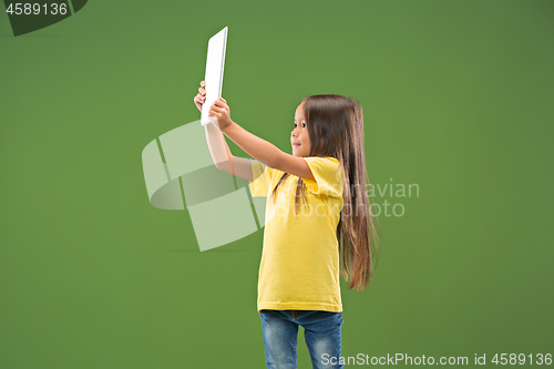 Image of Teen girl with laptop. Love to computer concept. Attractive female half-length front portrait, trendy green studio backgroud.