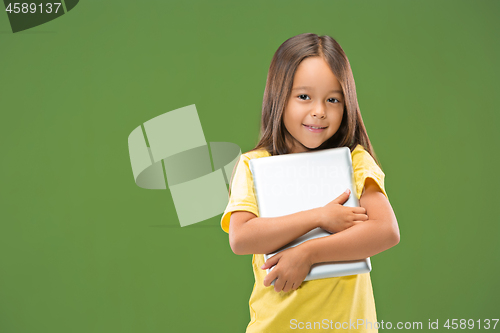 Image of Teen girl with laptop. Love to computer concept. Attractive female half-length front portrait, trendy green studio backgroud.