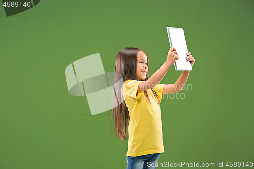 Image of Teen girl with laptop. Love to computer concept. Attractive female half-length front portrait, trendy green studio backgroud.