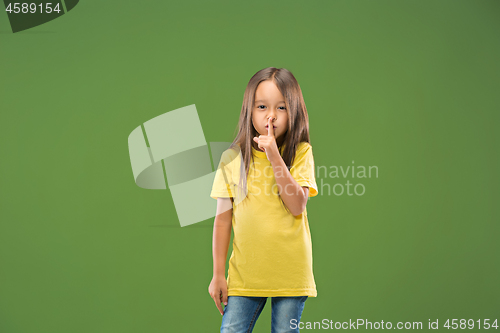 Image of The young teen girl whispering a secret behind her hand