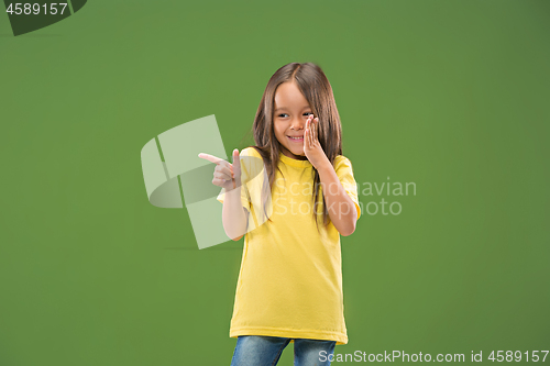 Image of The young teen girl whispering a secret behind her hand