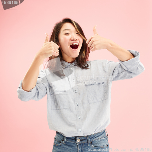 Image of The happy business woman standing and smiling against pink background.