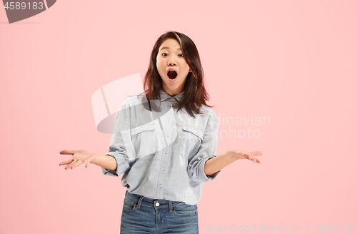 Image of Beautiful female half-length portrait isolated on pink studio backgroud. The young emotional surprised woman