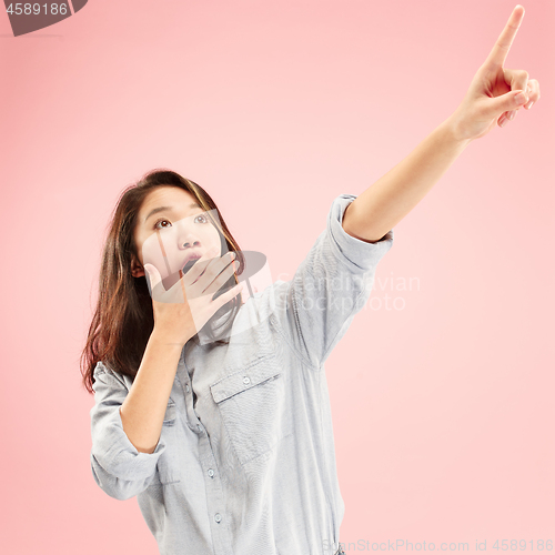 Image of Beautiful woman looking suprised isolated on pink