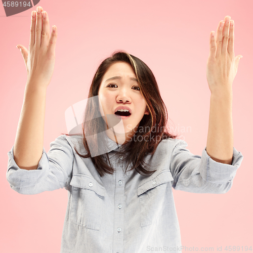 Image of Beautiful female half-length portrait isolated on pink studio backgroud. The young emotional surprised woman