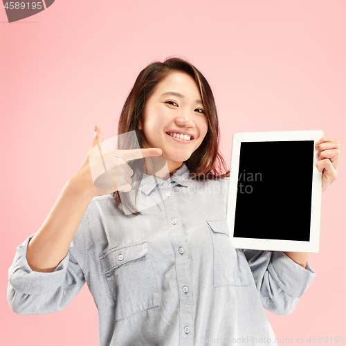 Image of Portrait of a confident casual girl showing blank screen of laptop isolated over pink background