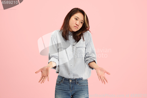 Image of Beautiful woman looking suprised and bewildered isolated on pink