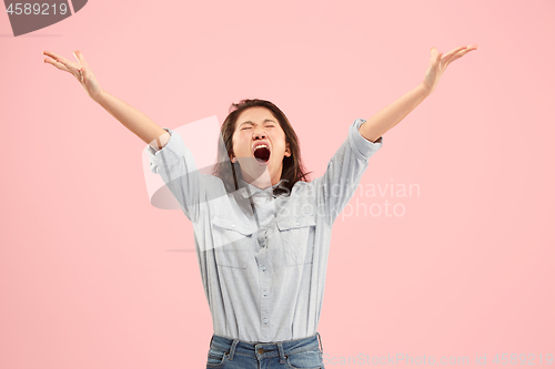 Image of The young emotional angry woman screaming on studio background