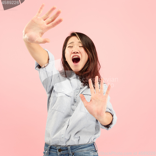 Image of Portrait of the scared woman on pink