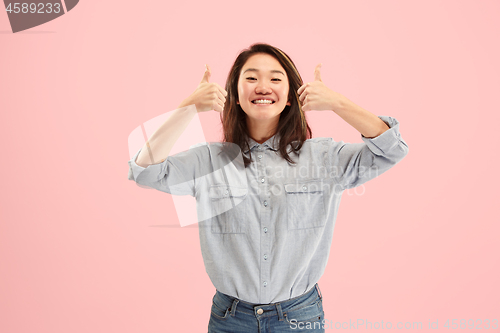 Image of The happy business woman standing and smiling against pink background.