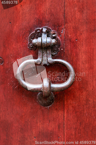 Image of Vintage bright red wooden door with metallic knocker