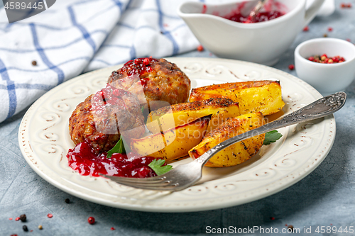 Image of Meat cutlets are served with potatoes and lingonberry sauce.