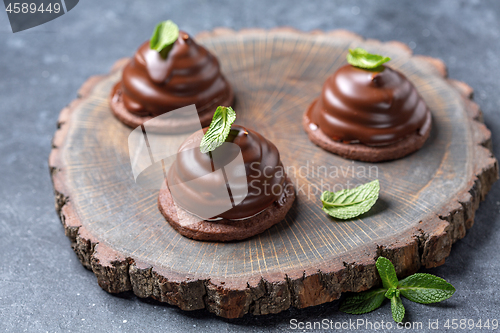 Image of Chocolate mini cakes with green mint leaves.