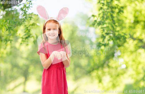 Image of happy red haired girl wearing easter bunny ears