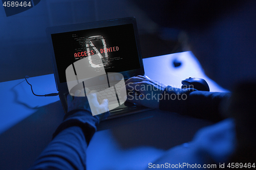 Image of hands of hacker with access denied message laptop