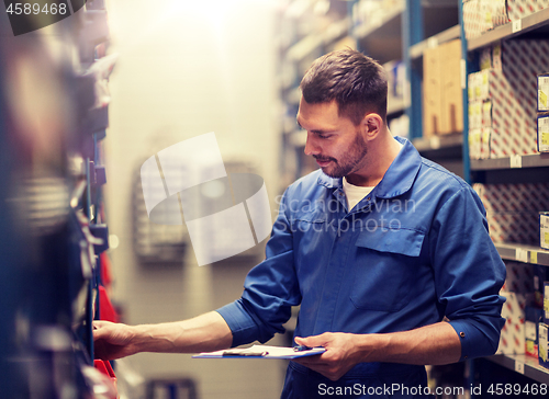 Image of auto mechanic with clipboard at car workshop