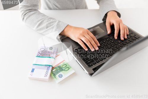 Image of close up of businesswoman with laptop and money