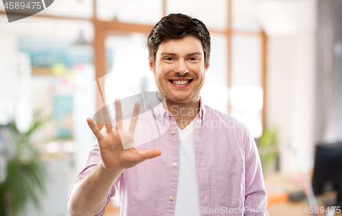 Image of young man showing five fingers over office room