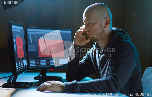 Image of hacker with no access on computer calls on cell