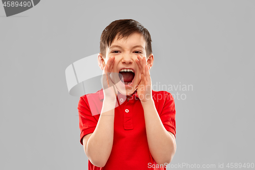 Image of angry little boy in red polo t-shirt screaming