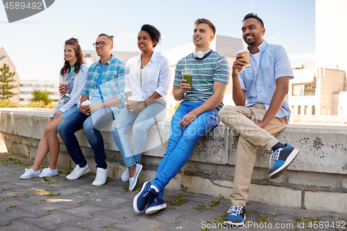 Image of friends drinking coffee and juice talking in city