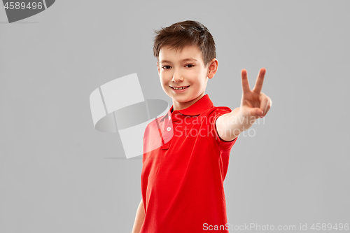 Image of smiling boy in red t-shirt showing peace gesture