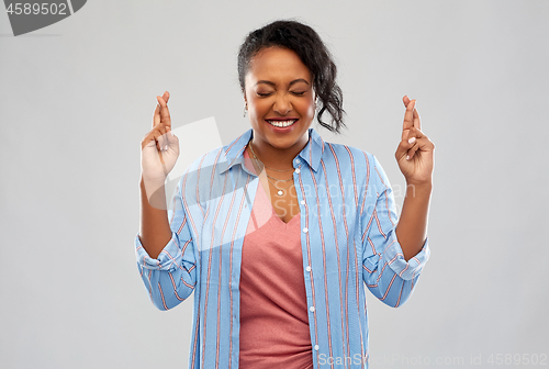 Image of african american woman holding fingers crossed