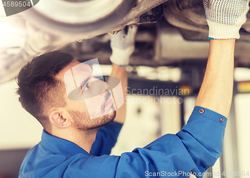 Image of mechanic man or smith repairing car at workshop