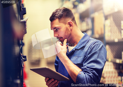 Image of auto mechanic or smith with tablet pc at workshop