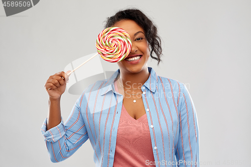 Image of happy african american woman with big lollipop