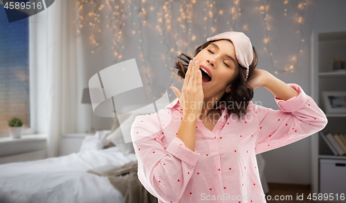 Image of happy young woman in pajama and eye sleeping mask