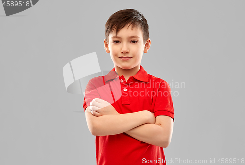 Image of smiling boy in red t-shirt with crossed arms