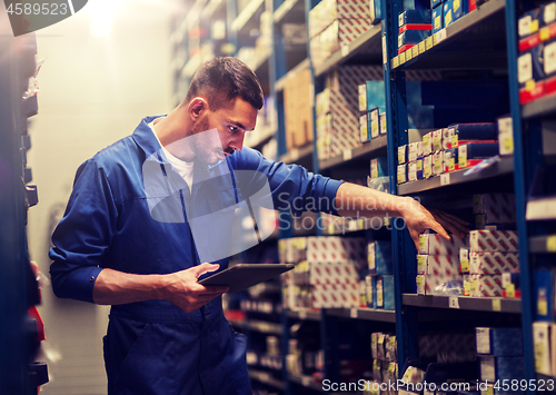 Image of auto mechanic or smith with tablet pc at workshop