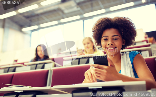 Image of african student girl with smartphone at lecture