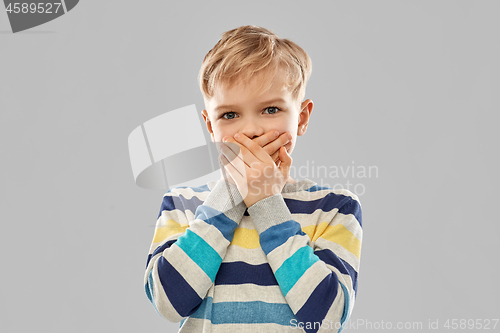 Image of shocked little boy closing his mouth by hands