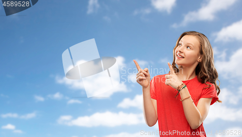 Image of smiling teenage girl pointing fingers to something