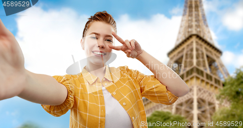 Image of teenage girl taking selfie over eiffel tower