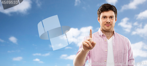 Image of young man showing one finger over sky