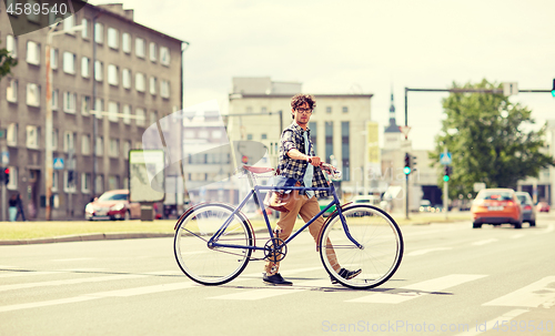 Image of young man with fixed gear bicycle on crosswalk