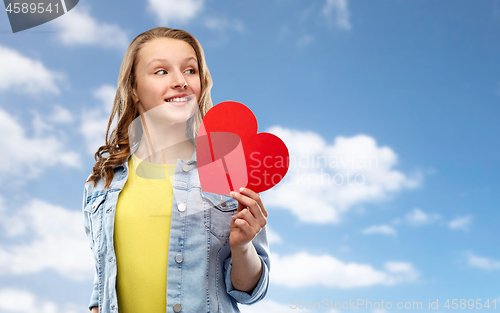 Image of smiling teenage girl with red heart over sky