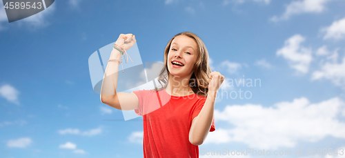 Image of happy teenage girl in red celebrating triumph