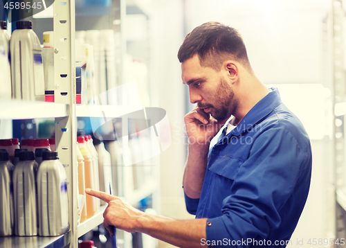 Image of auto mechanic with clipboard at car workshop