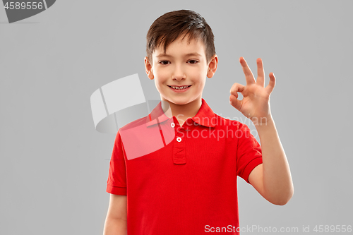 Image of smiling boy in red t-shirt showing ok hand sign