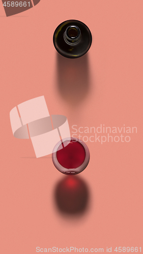 Image of Red wine in a glass with opened bottle with shadows.