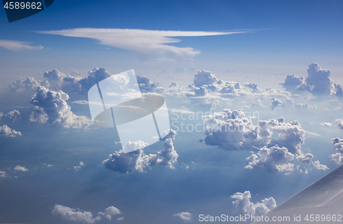 Image of Part of plane wing on a background of blue cloudy sky.