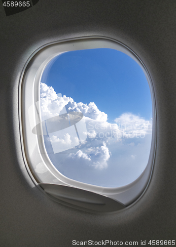 Image of Airplane window with picture of sky cloudy aerial view.