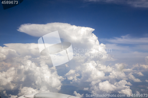 Image of View frome plane onto wing and white clouds and sky.