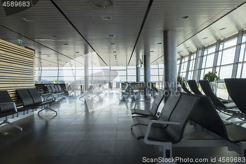 Image of Airport terminal with empty chairs for waiting departure.