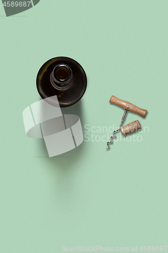 Image of Opened bottle of wine with corkscrew and cork.